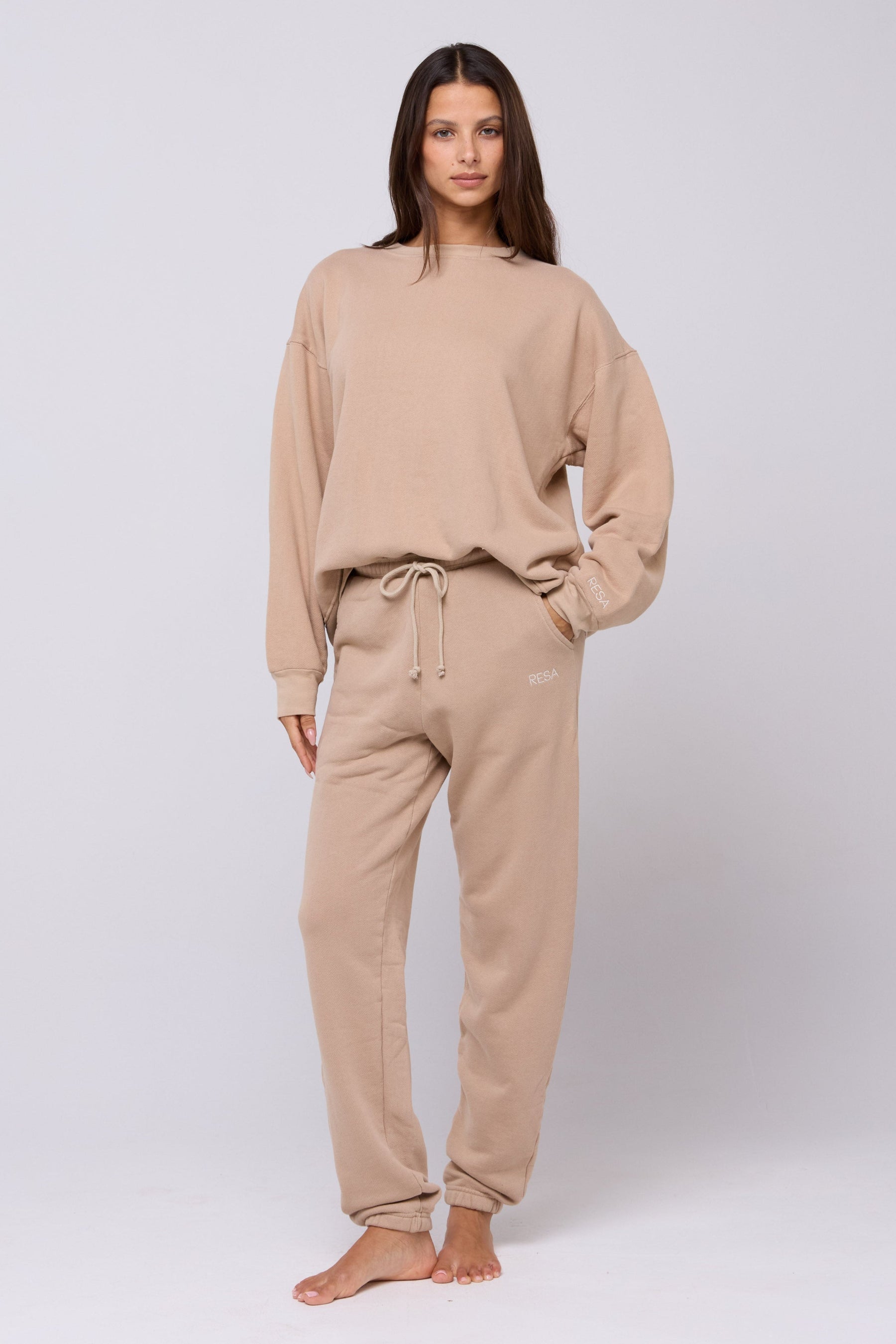 This is an image of Bodhi Sweatpants in Sand - RESA featuring a model wearing the dress