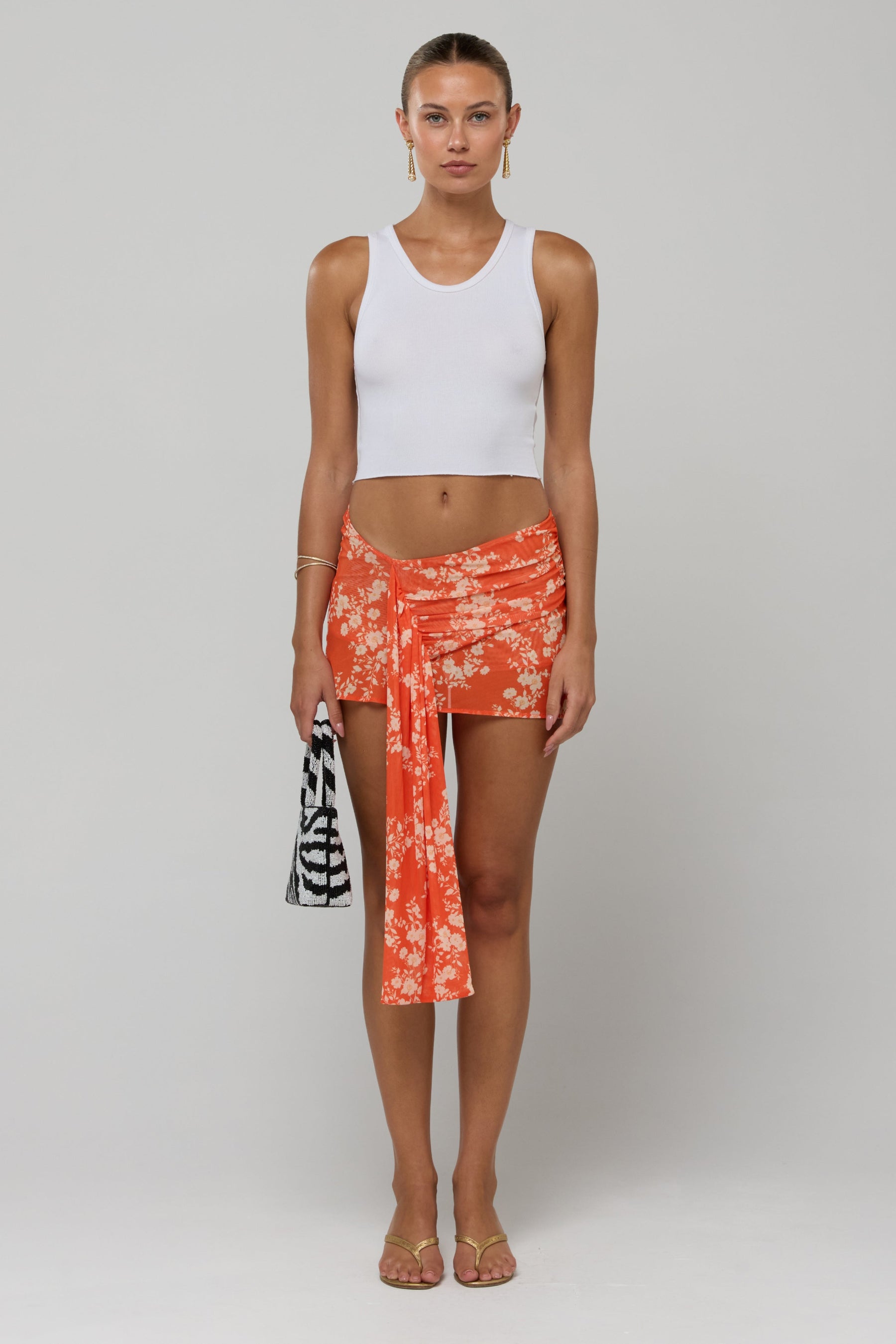This is an image of Lucy Mini Skirt in Orange Blossom - RESA featuring a model wearing the dress