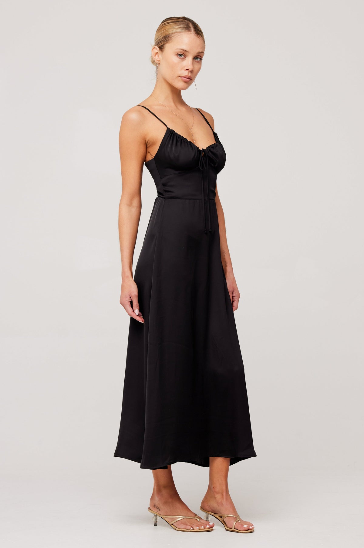 This is an image of Kaitlyn Midi in Black - RESA featuring a model wearing the dress