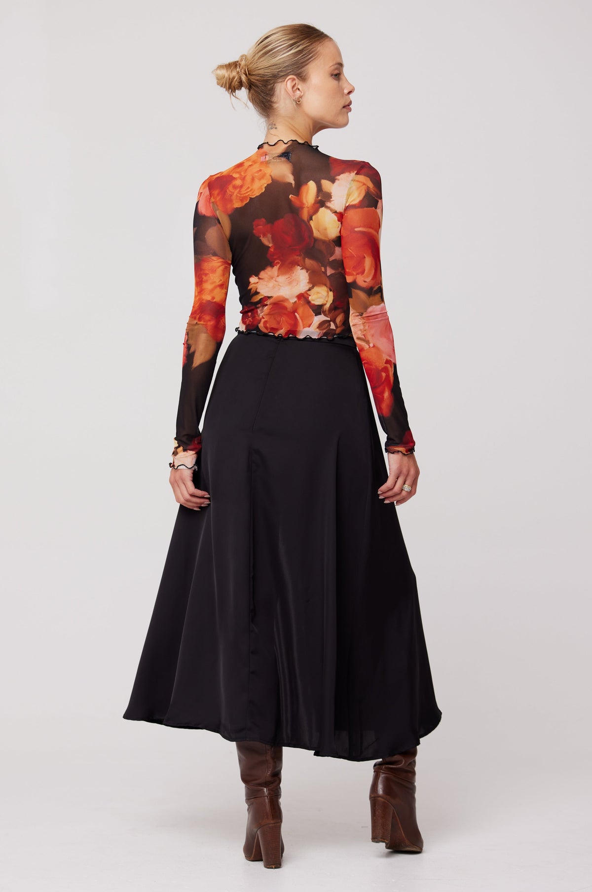 This is an image of Skatie Midi Skirt in Black - RESA featuring a model wearing the dress